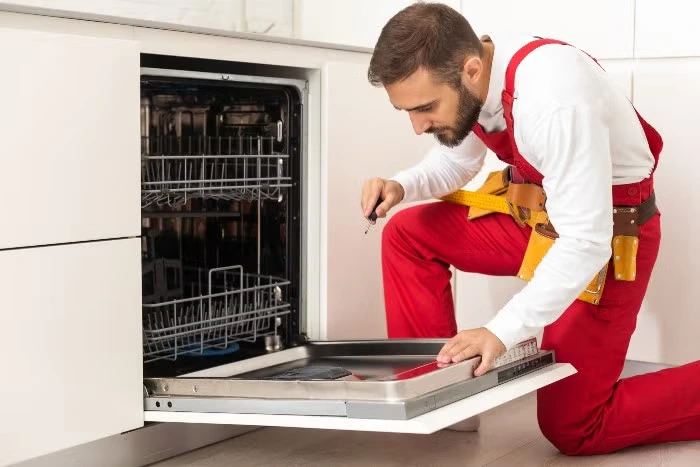 Appliance repair technician working on a dishwasher