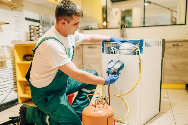 Technician inspecting an appliance during repair